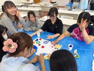 札幌国際大学　臨床心理　絵の具を指につけ、グループで1枚の作品を作る様子